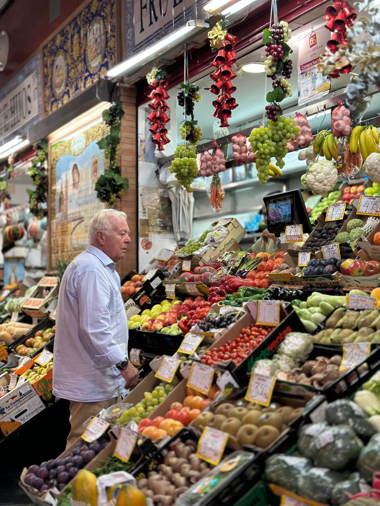 man looking at market stand filled with produce
