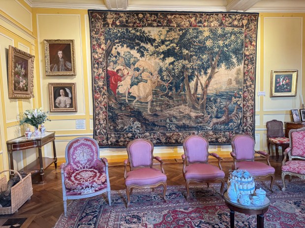 sitting room with large tapestry on the back wall