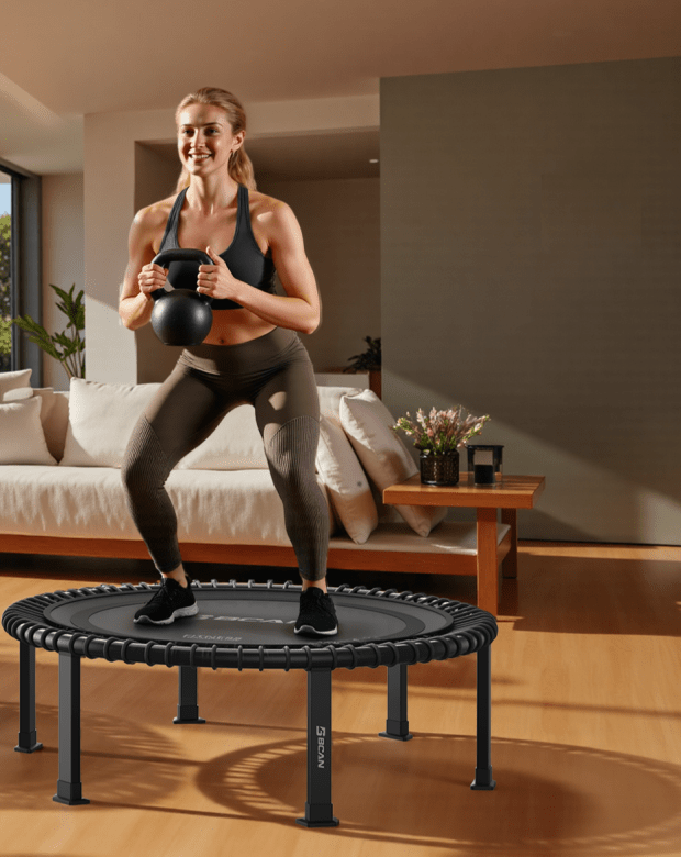 Woman with kettle bell standing on fitness trampoline